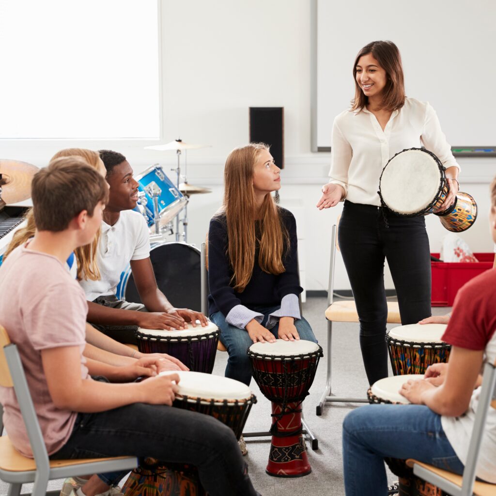 Une entrepreneuse anime une activité de tambour en groupe pour renforcer la cohésion d’équipe après une reprise d’entreprise à Vertou