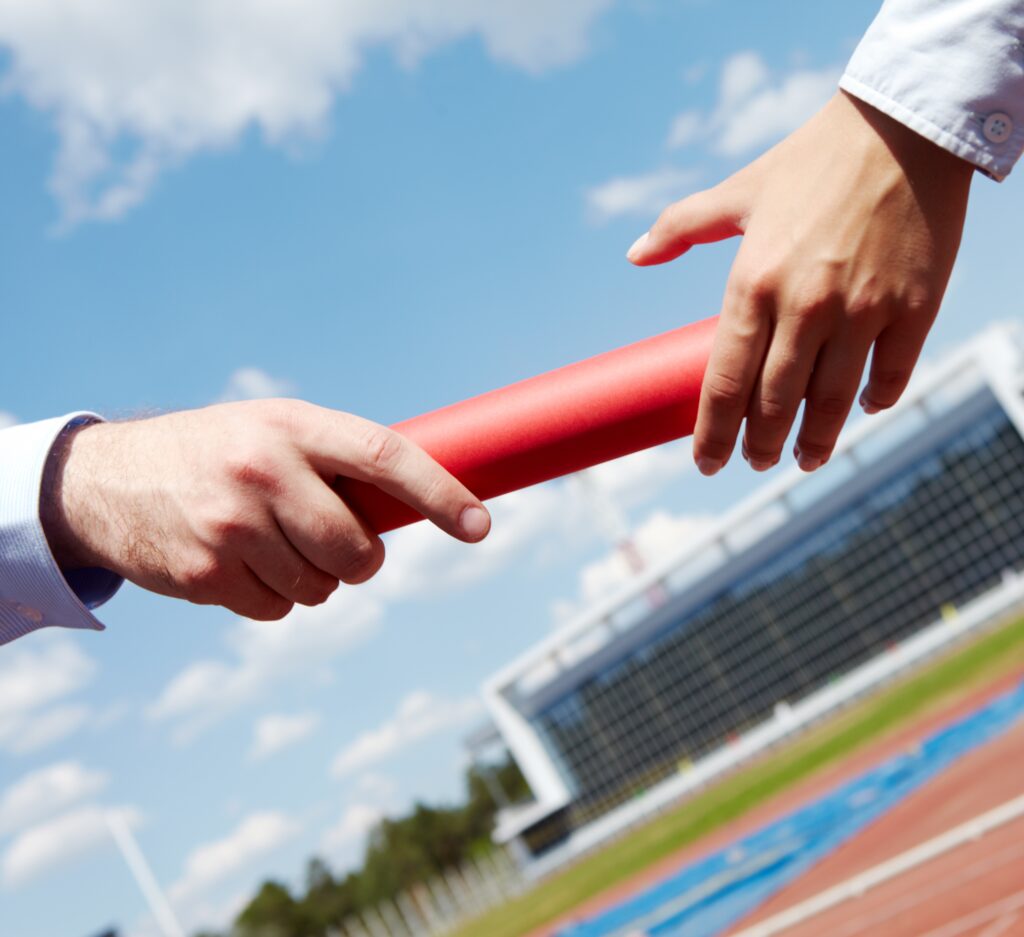 Deux entrepreneurs se transmettant un témoin symbolisant la reprise d’entreprise à Vertou et la passation juridique entre cédant et repreneur